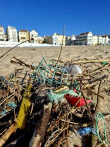 Cordas e fragmentos de lixo marinho presos na praia depois da tempestade.